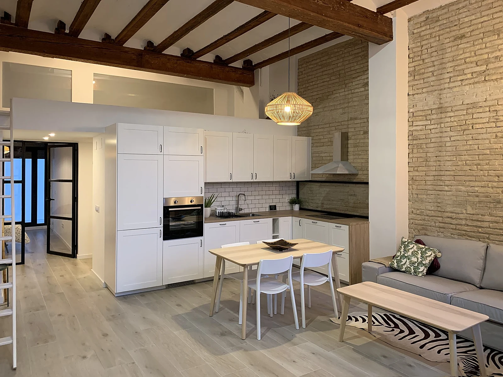 Cocina con vigas de madera y ladrillo visto de la Casa UM en Ciutat Vella, Valencia